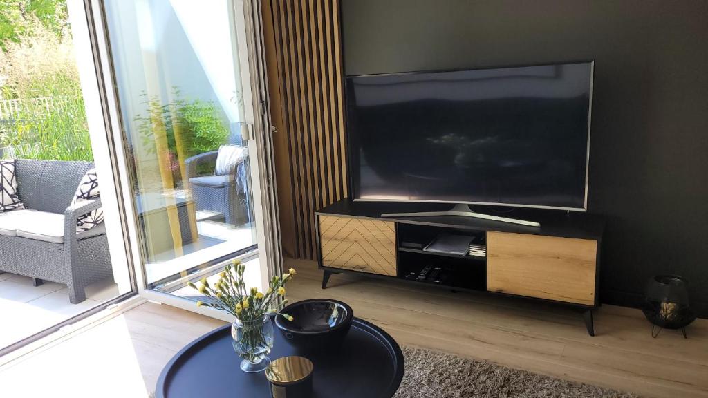 a living room with a large flat screen tv at apartament przy plaży w redłowie in Gdynia
