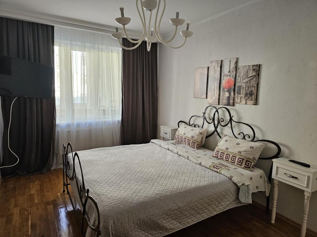 Schlafzimmer mit einem Bett und einem Kronleuchter in der Unterkunft Negruzzi 2 bedrooms in Chişinău