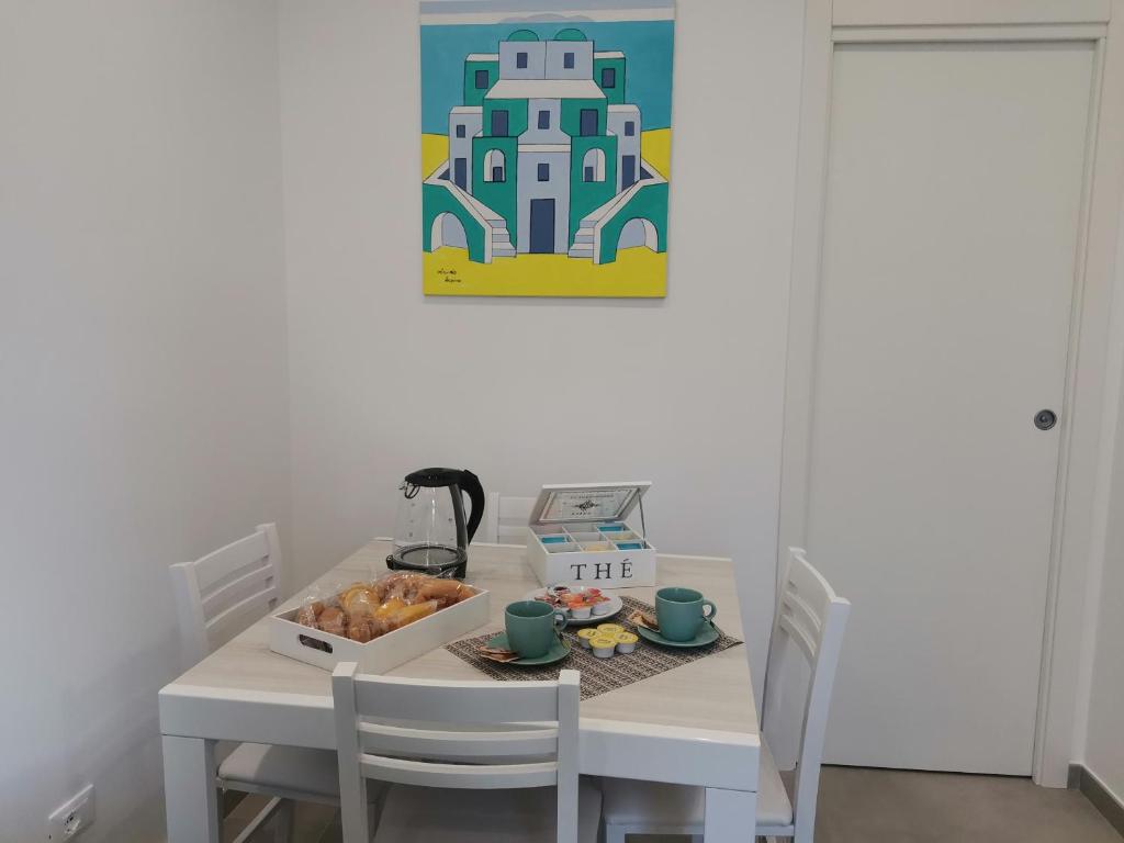 una mesa blanca con una caja de comida. en Casa Verdemare, en Isquia