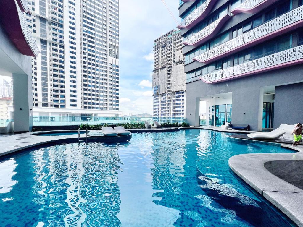 a large swimming pool in a building with tall buildings at Arte Plus Ampang By The Relax Stay in Kuala Lumpur