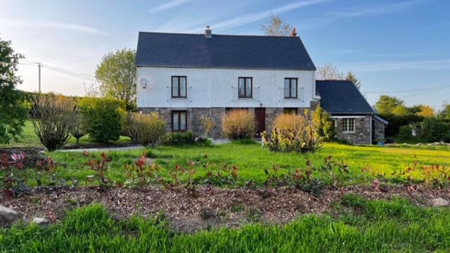 uma grande casa branca com um jardim em frente em 3 bedroom farmhouse in Normandy em Gathemo