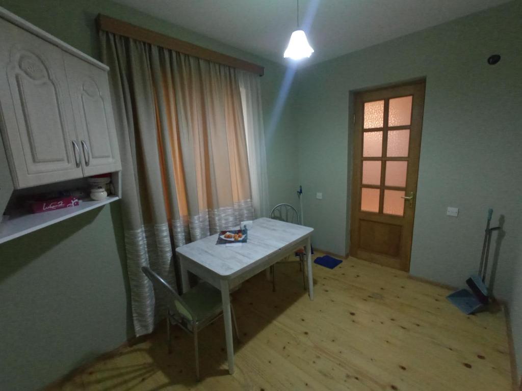 Zimmer mit einem Tisch, einem Fenster und einer Tür in der Unterkunft Art Racha in Ambrolauri