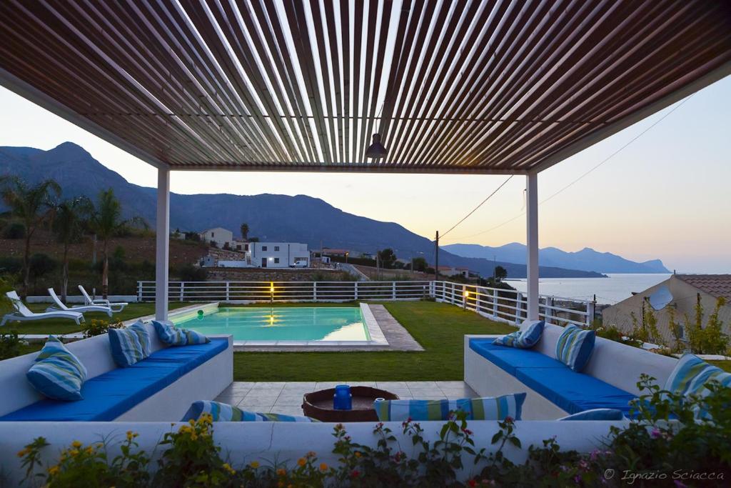 a patio with blue couches and a swimming pool at Casa Azul in Castellammare del Golfo