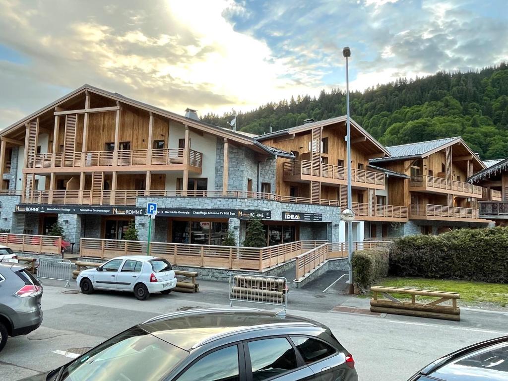 un gran edificio con coches estacionados en un estacionamiento en GESPERE LE STELLA, en Les Gets