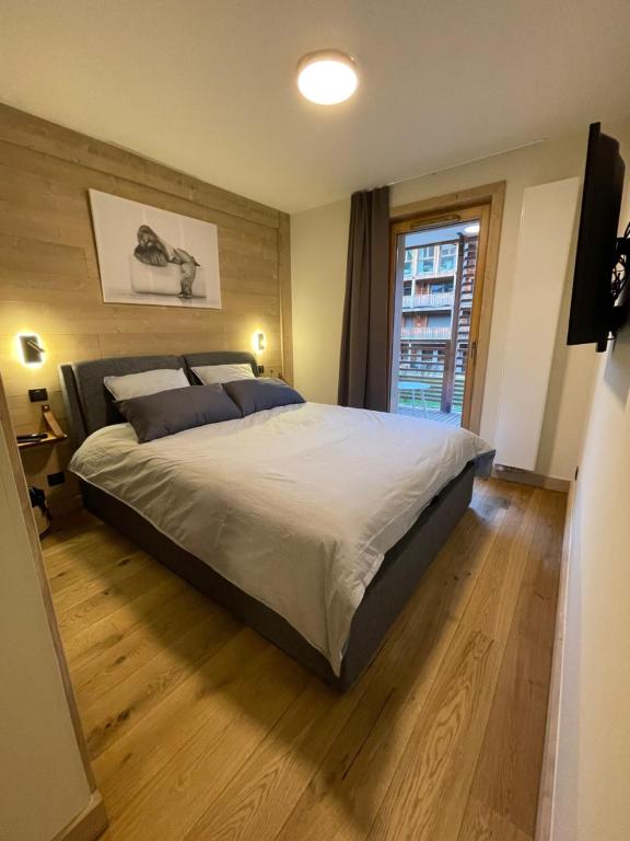 a bedroom with a large bed and a window at GESPERE LE STELLA in Les Gets