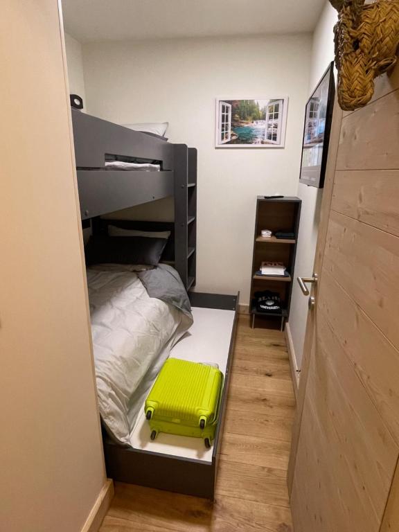 a small bedroom with a bunk bed with a yellow suitcase at GESPERE LE STELLA in Les Gets