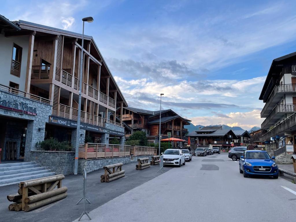 a street in a town with parked cars and buildings at GESPERE LE STELLA in Les Gets