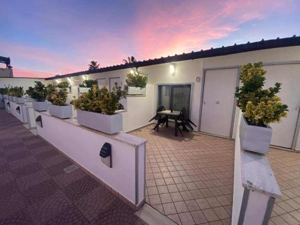 une rangée de plantes en pot sur le côté d'un bâtiment dans l'établissement Airport Hotel, à Fiumicino