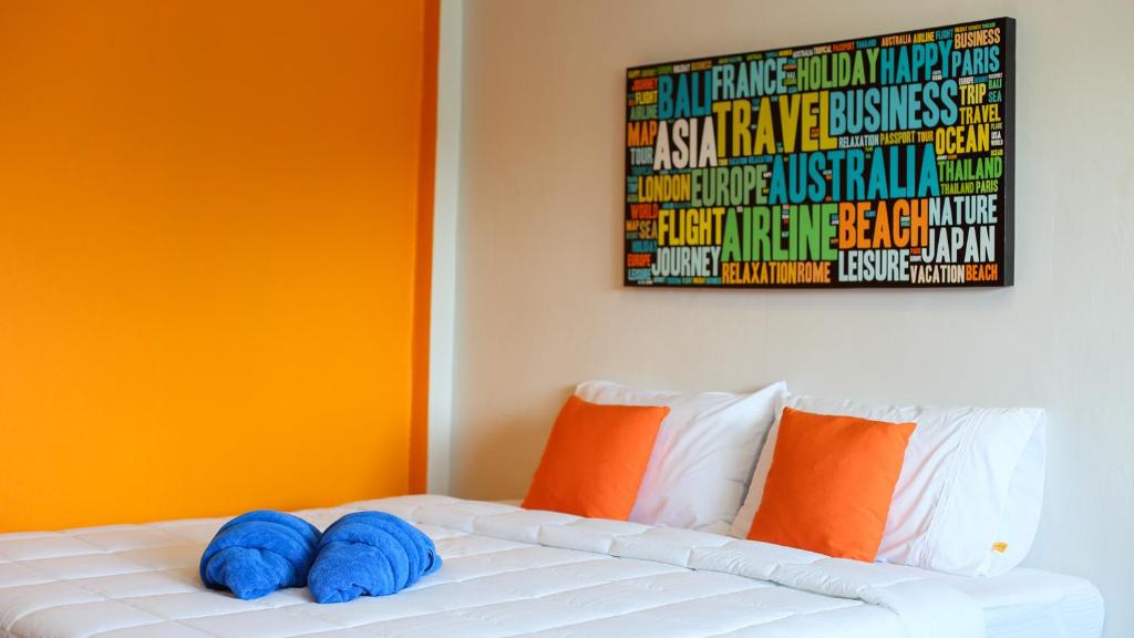 Una cama con dos almohadas azules encima. en Bangtao Guest House, en Bang Tao Beach