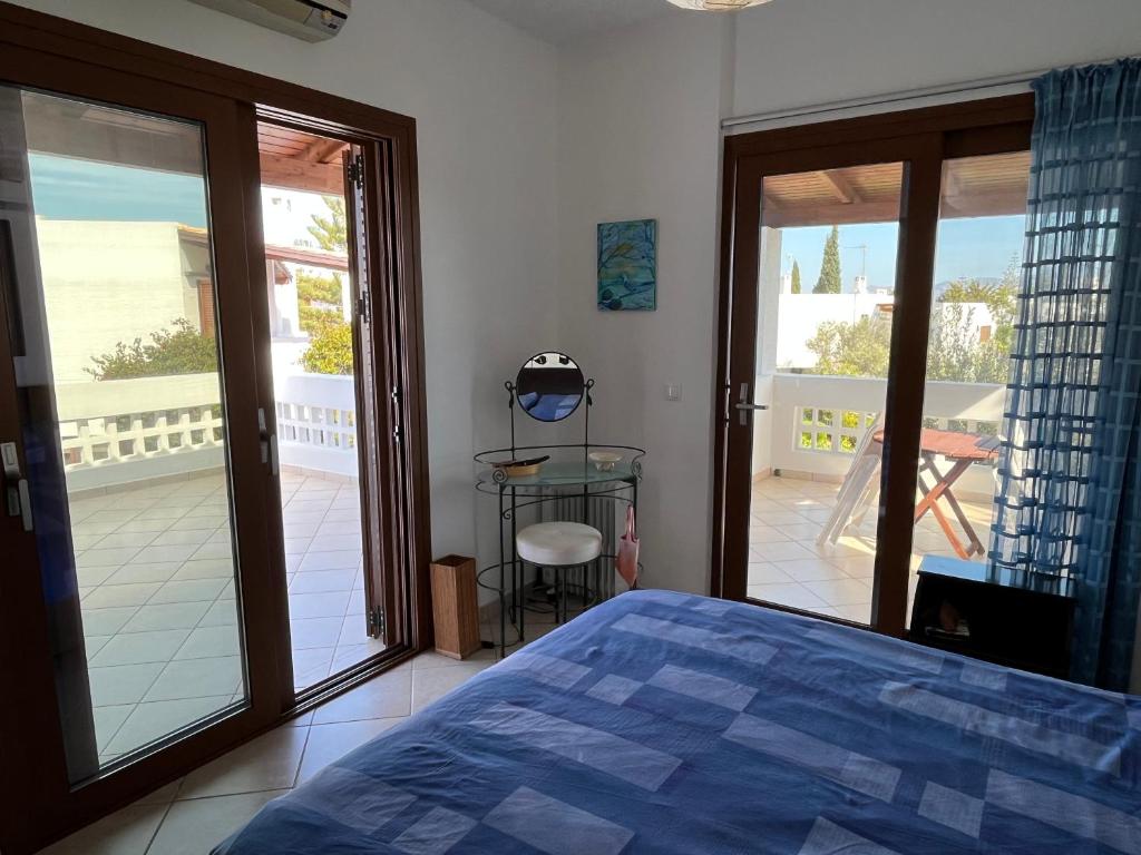 ein Schlafzimmer mit Bett und Blick auf einen Balkon in der Unterkunft Porto Hydra - Villa Mirani in Ermioni