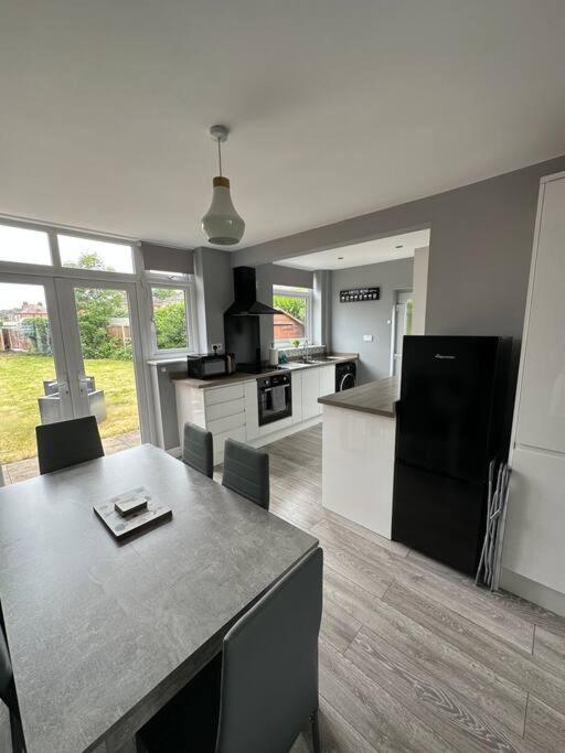 a kitchen with a table with chairs and a counter top at Fabulous 3bed off street parking in Stafford