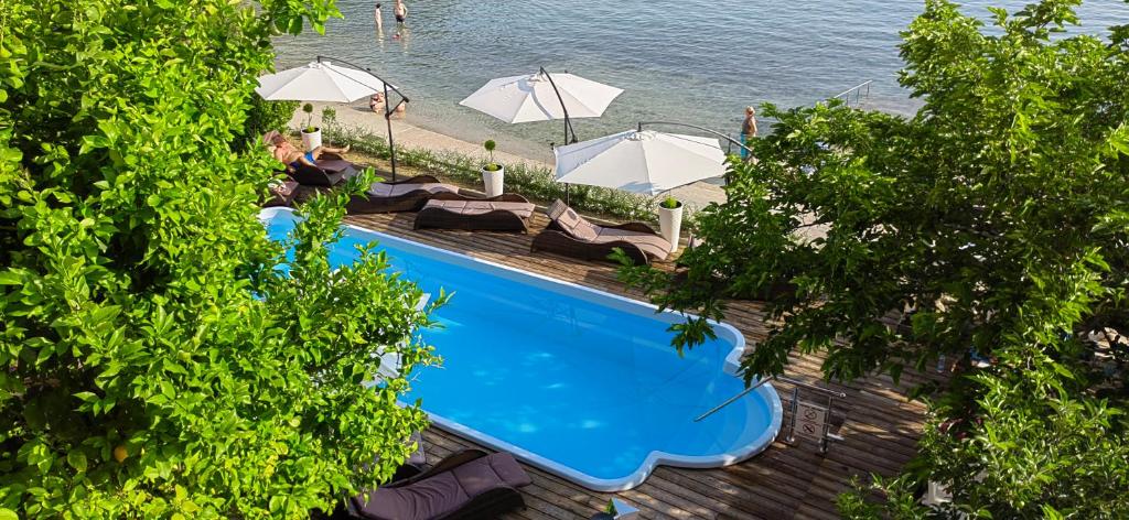 an overhead view of a swimming pool with umbrellas at Apartman Hana 2 in Rab