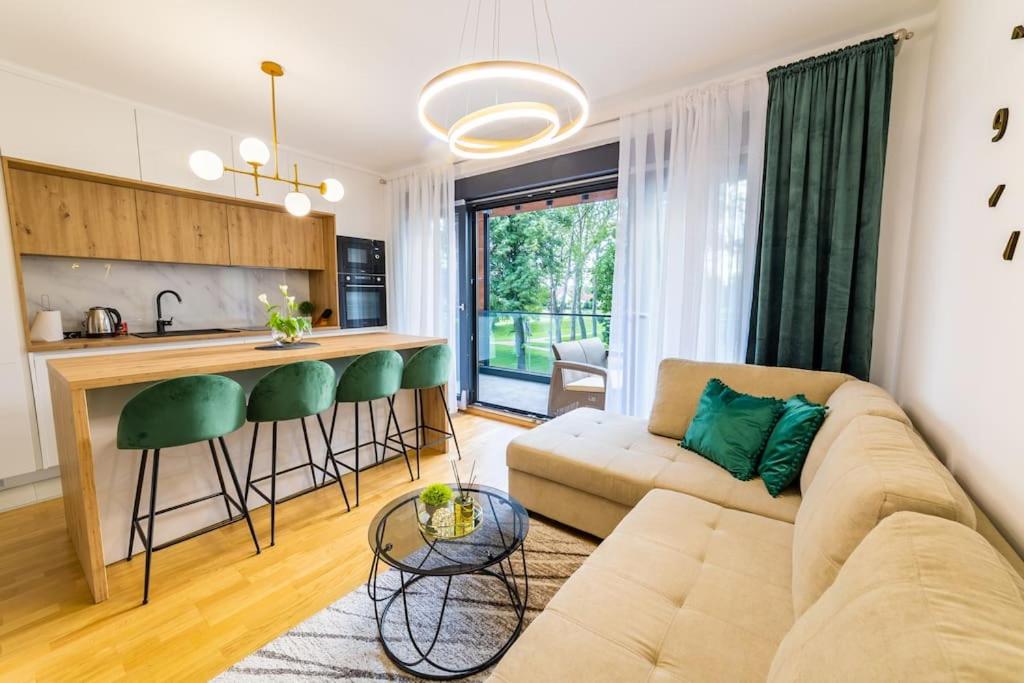 a living room with a couch and a kitchen at Apartman Lux in Virovitica