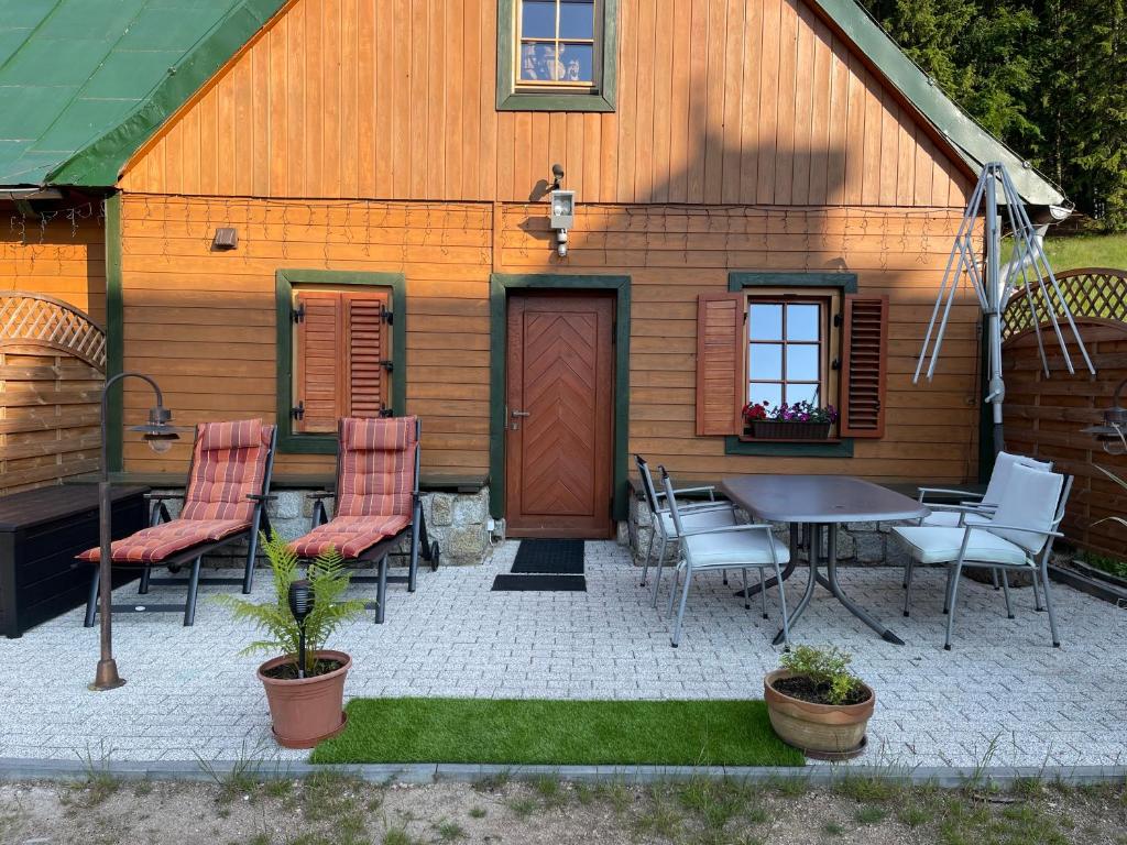 un patio con sillas y una mesa frente a una casa en Chybotek Premium Apartments en Przesieka