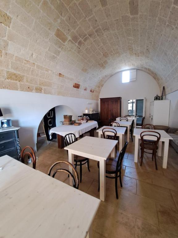 a room with tables and chairs and a brick wall at La Fragna in Nardò