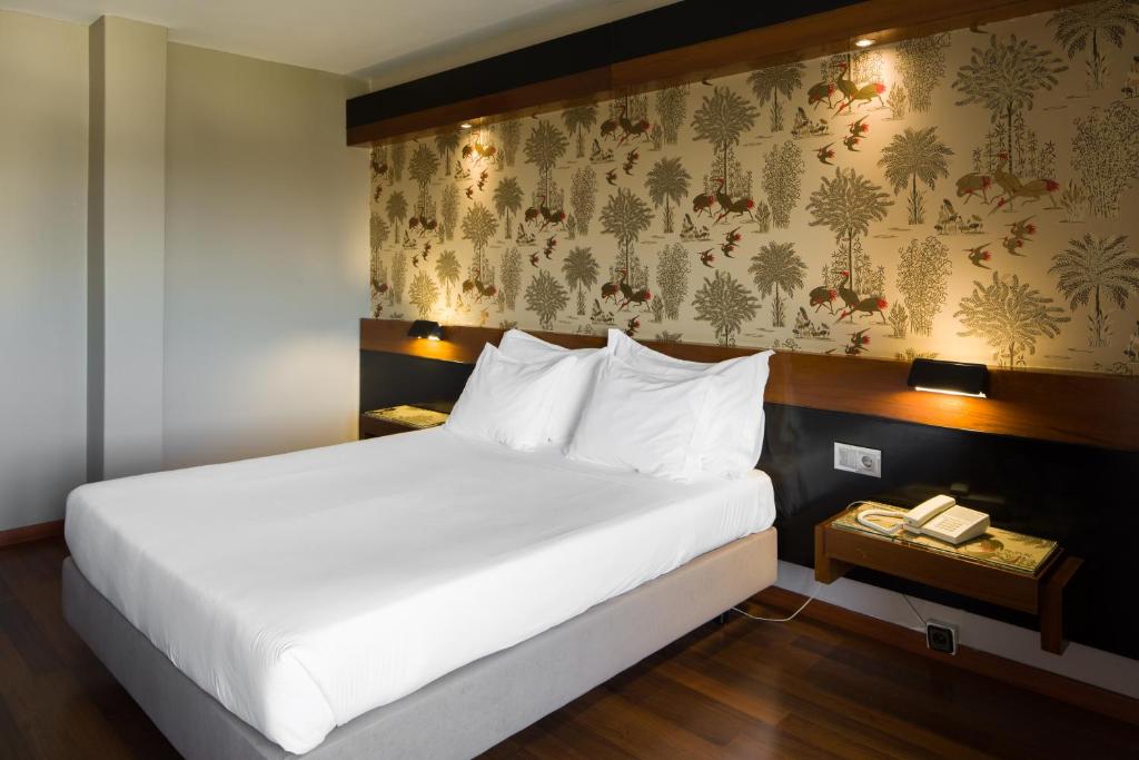 Un dormitorio con una gran cama blanca y una pared en Hotel Lara, en Valença