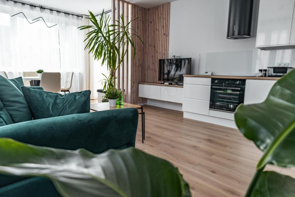 a living room with a couch and some plants at Apartament 2 Komfort in Słupsk