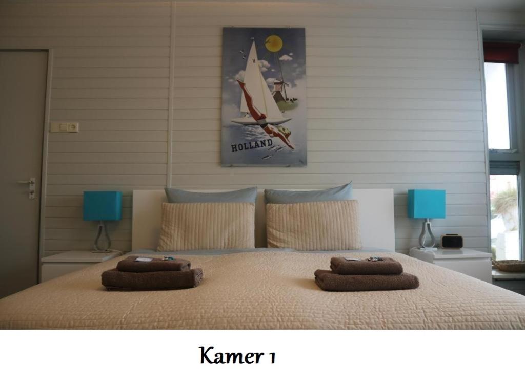 a bedroom with a large bed with two pillows on it at Zeelui in Egmond aan Zee