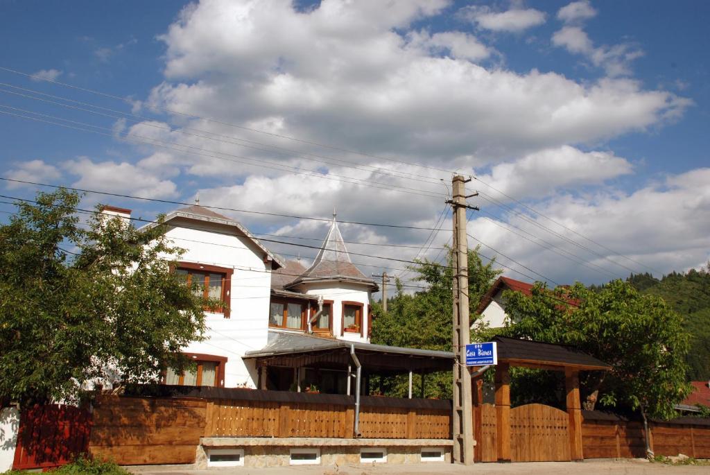 a white house with a fence in front of it at Pensiunea Casa Bianca - Bucovina in Vama