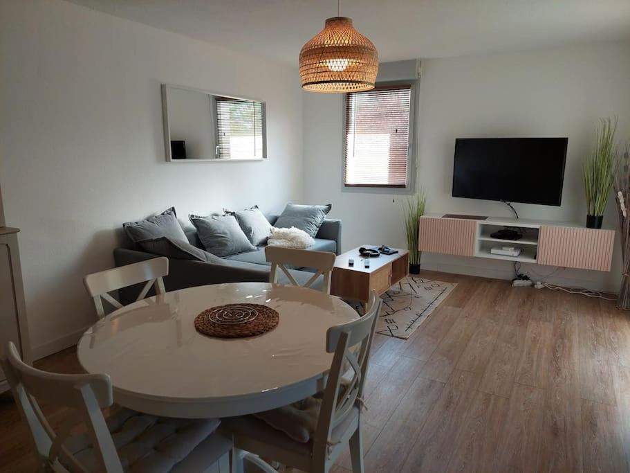 - un salon avec une table et un canapé dans l'établissement Appartement 65 m² avec piscine., à Tours