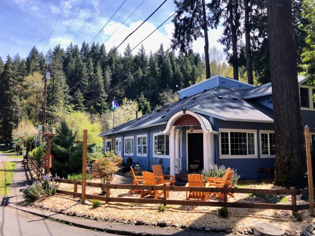 a blue house with chairs in front of it at Westfir Lodge in Oakridge