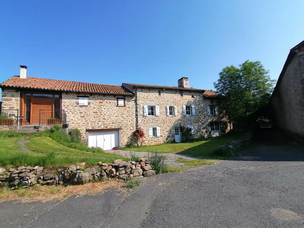 une grande maison en pierre sur le côté d'une route dans l'établissement Le Relais d'Anglards, à Anglards-de-Saint-Flour