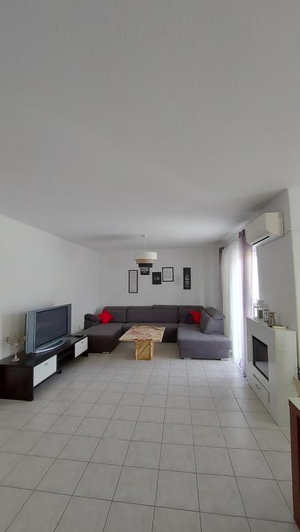 a living room with a couch and a tv at Apartmani Galiot in Kaštela