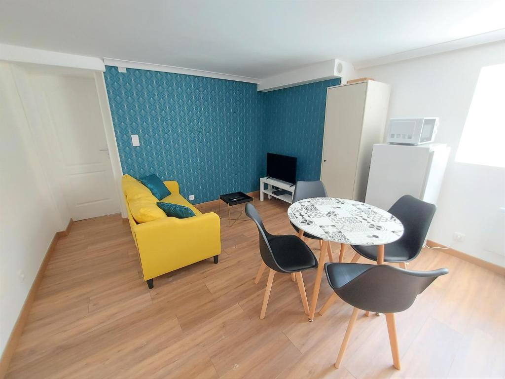 a living room with a yellow couch and a table at ° Appart 3 - Lunéville centre ° in Lunéville