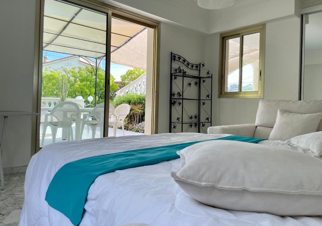 a bedroom with a large bed and a balcony at Rez de jardin de 65m2 dans villa à Nice in Nice