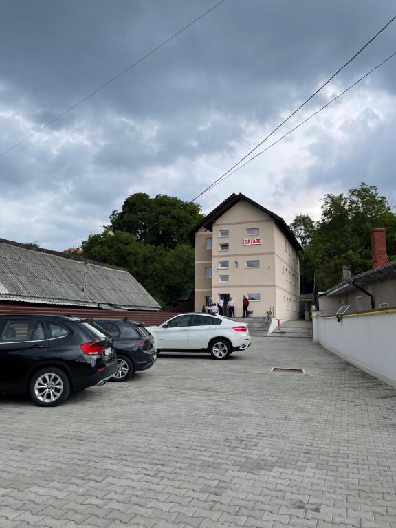 two cars parked in a parking lot in front of a building at Cazare apartamente LAVI-TOUR Tg Neamț in Târgu Neamț