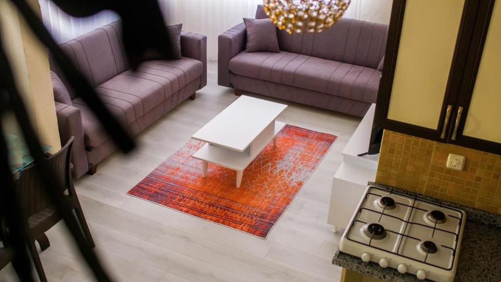 Sala de estar con sofás morados y mesa de centro en BELİS APART & PANSİYON, en Kemer