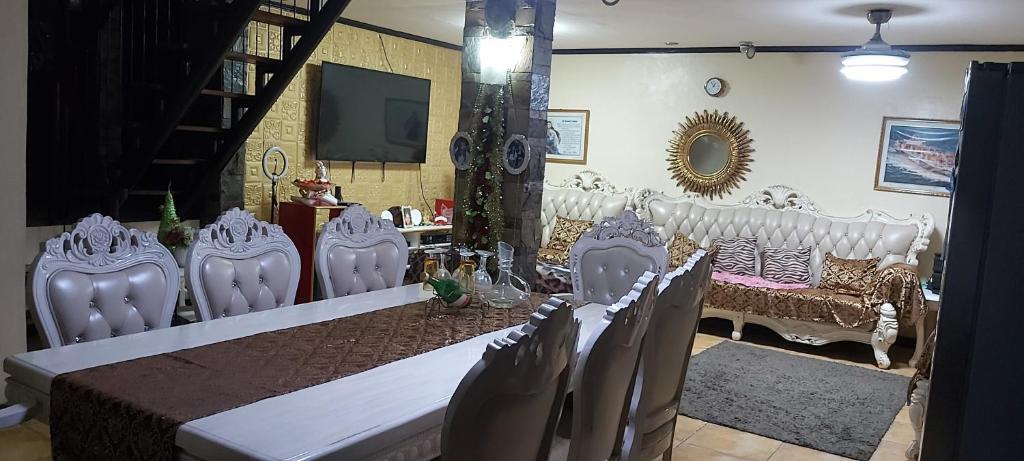 comedor con sillas blancas y mesa en RoomForRent en Balibago