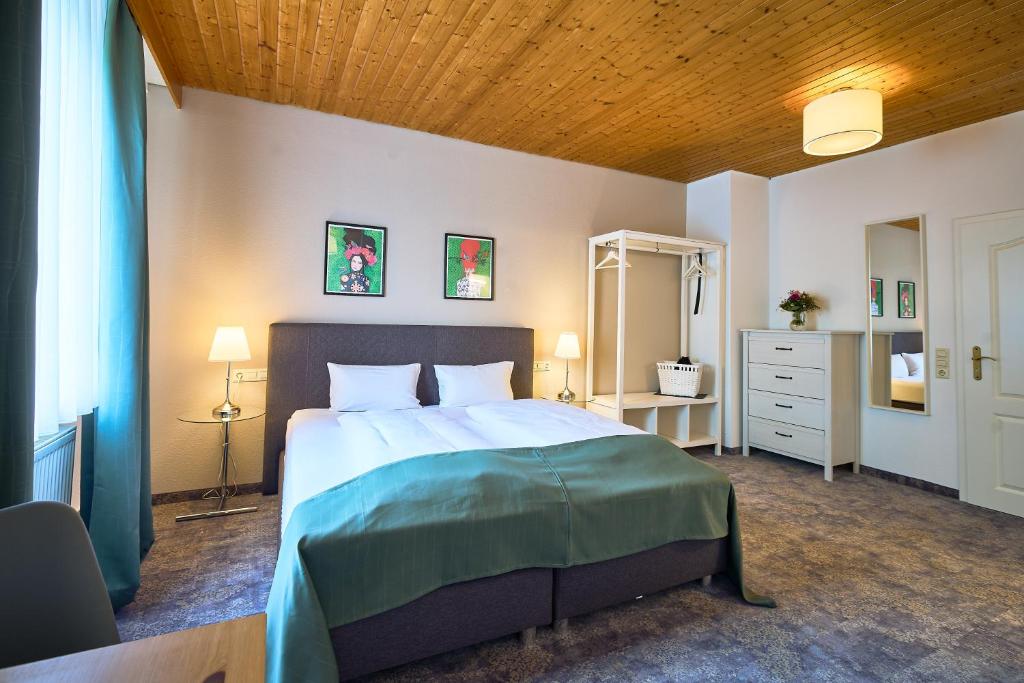 ein Schlafzimmer mit einem großen Bett und einer Holzdecke in der Unterkunft Landgasthof Hirsch in Baden-Baden