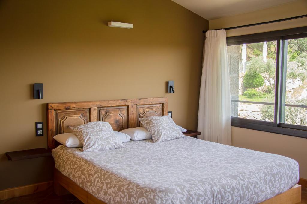 1 dormitorio con cama con almohadas y ventana en Mas Rovira, en Banyoles