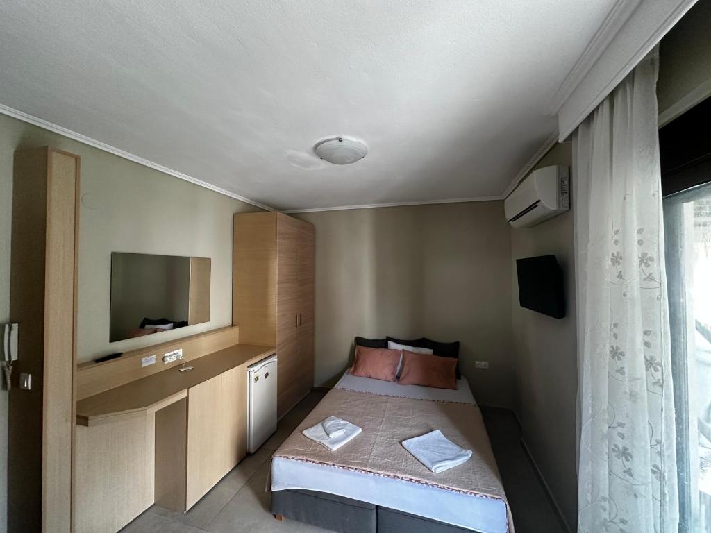 a small bedroom with a bed and a television at Apartment GM in Neoi Epivates