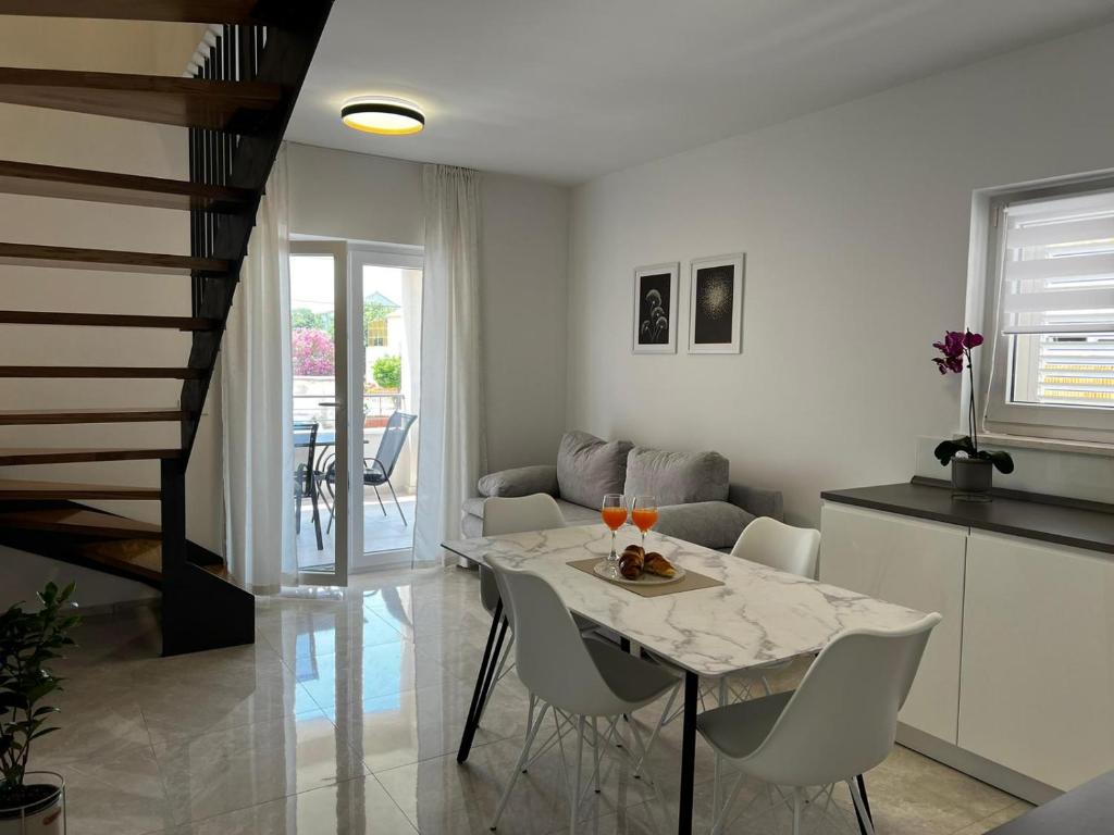 een keuken en eetkamer met een tafel en stoelen bij Holiday Home Bajlo in Zadar