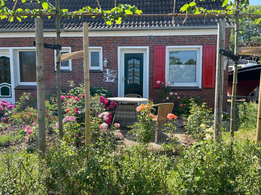 a garden in front of a house with a red door at La Petite Gloire in Pogum