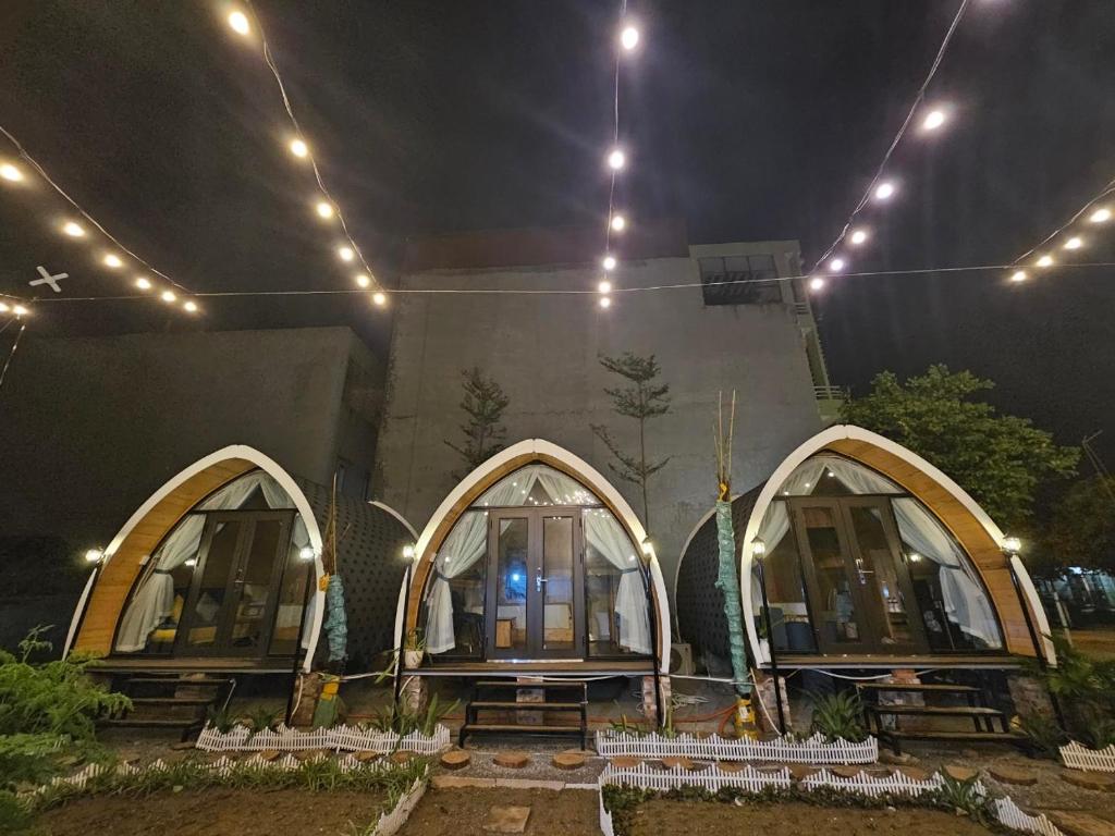 a building with three arched windows at night at Mio Hotel in Hải Dương