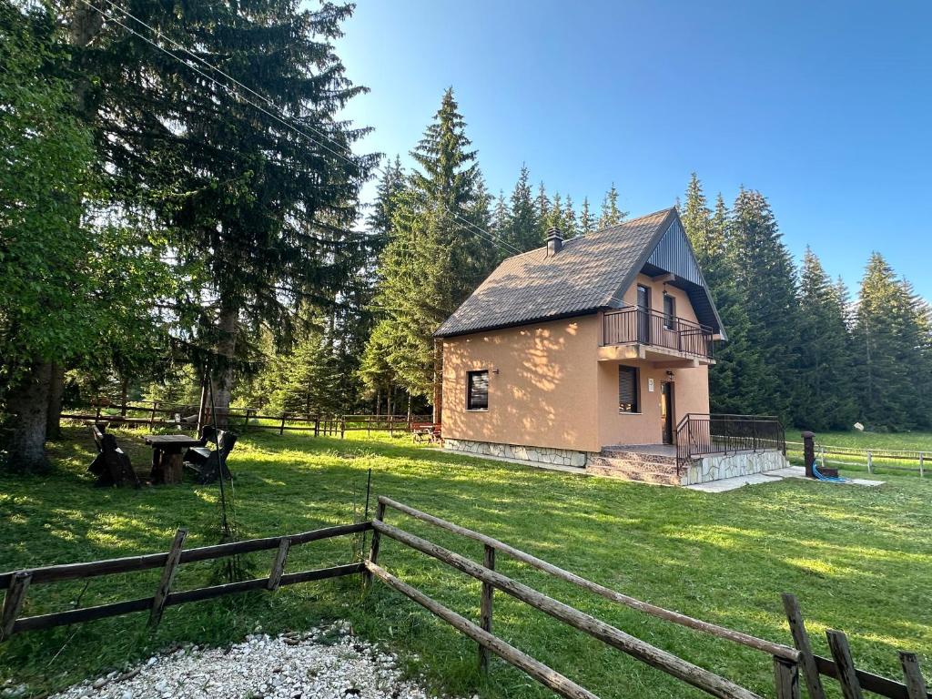 una piccola casa in un campo con una recinzione di Stojovic house a Žabljak