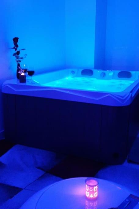 Zimmer mit einer Badewanne mit blauem Licht in der Unterkunft Dieppe Love-amour in Dieppe