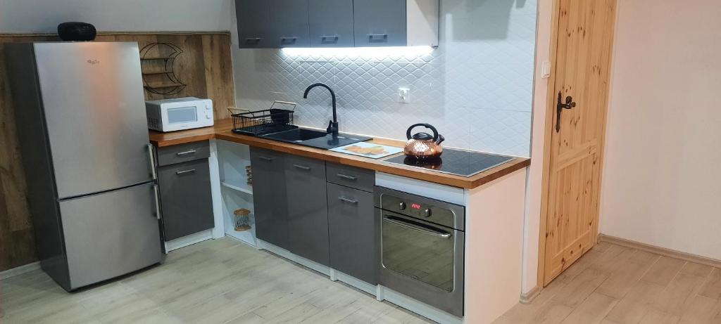a kitchen with a sink and a refrigerator at Apartament Świerkowa 11 in Augustów