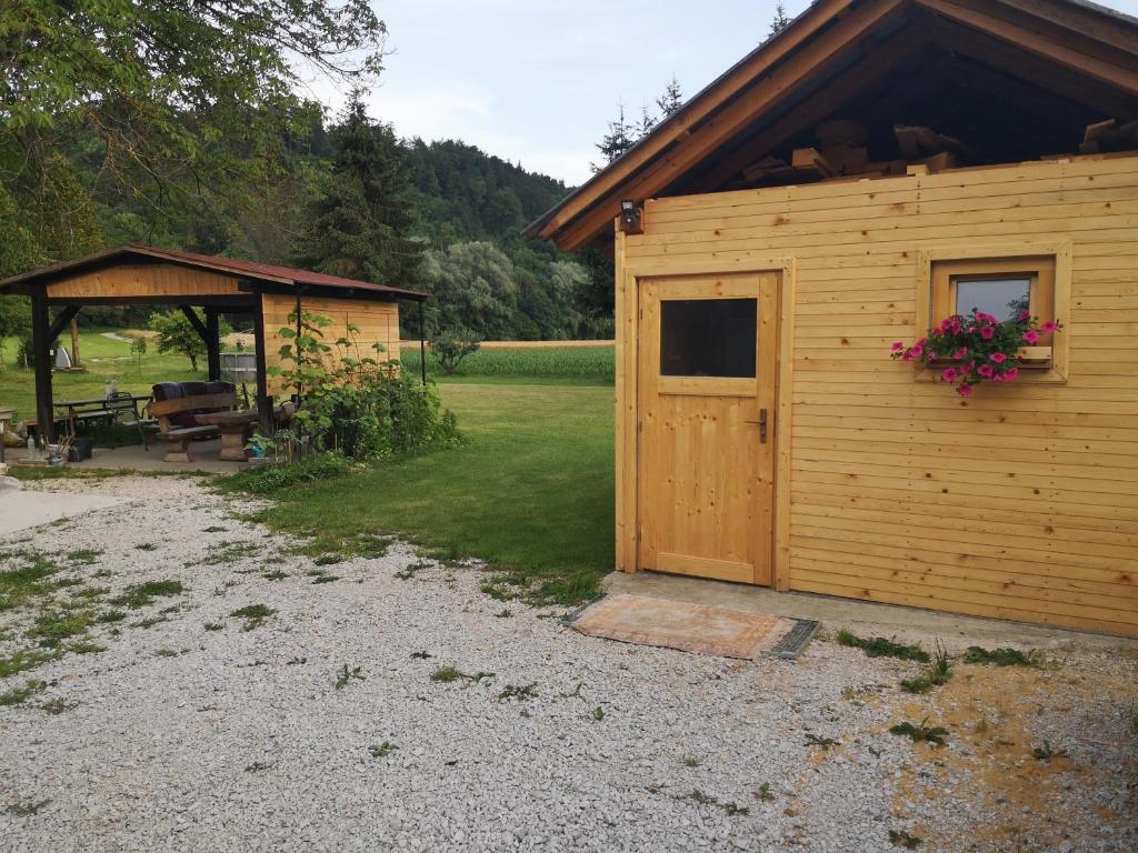 eine Holzhütte mit einer Tür und einem Pavillon in der Unterkunft Hiška Zeleni raj in Podnart