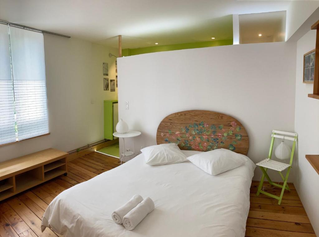 ein Schlafzimmer mit einem weißen Bett mit zwei Handtüchern darauf in der Unterkunft CHAMBRES D'HÔTES LA MADELEINE in Vienne-le-Château