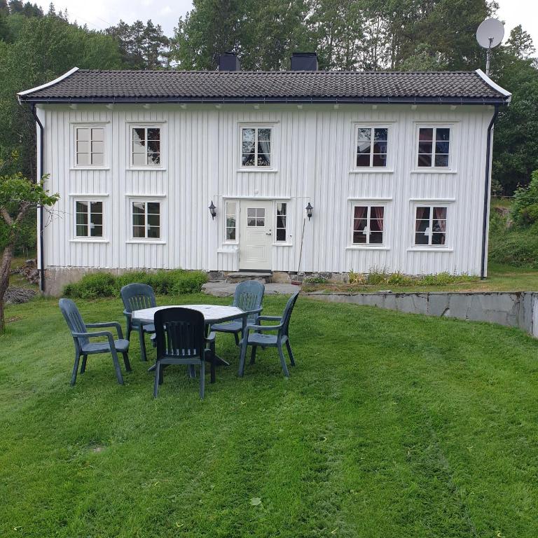 a table and chairs in front of a white house at Gårdshuset Håverstad in Iveland