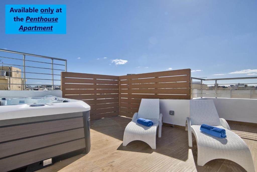 een balkon met 2 stoelen en een wastafel op een dak bij Tower Road - Central Sliema Modern Apartments and Duplex Penthouse by ShortletsMalta in Sliema