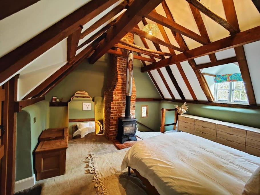 a bedroom with a large bed and a fireplace at The Snuggery 