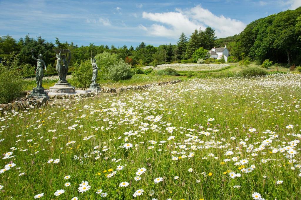 a field of flowers with statues in the middle at Orroland Holiday Cottages in Dundrennan
