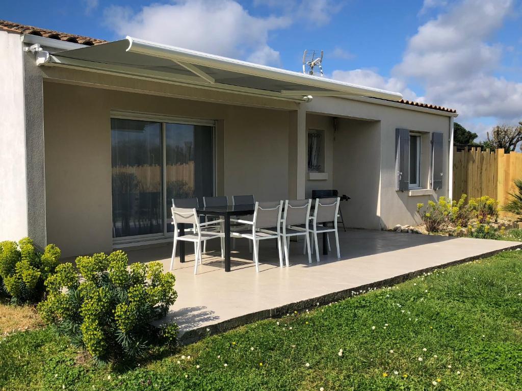 eine Terrasse mit einem Tisch und Stühlen darauf in der Unterkunft Iløt Vacances Le Château D Oleron in Le Château-dʼOléron