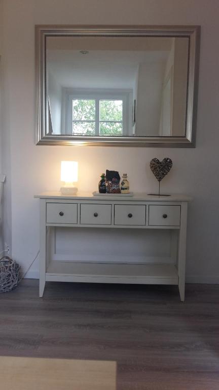 a white dresser in a room with a mirror at FeWo Baron in Kleinwessek