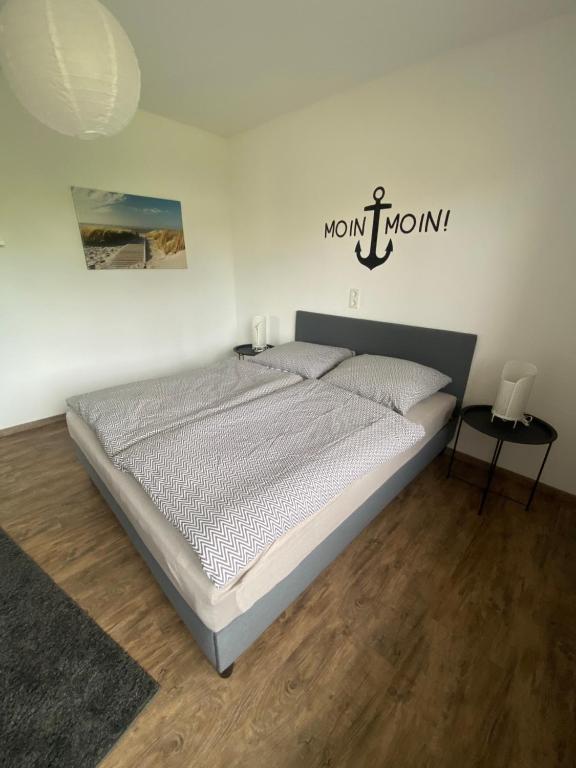 1 dormitorio con 1 cama con un cartel en la pared en FeWo Leo en Rastede